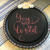 YOU ARE SO LOVED Hand Painted Mini Round Wooden Wall Art With White Flower Accents